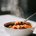 Two bowls of original cabbage soup recipe served with bread