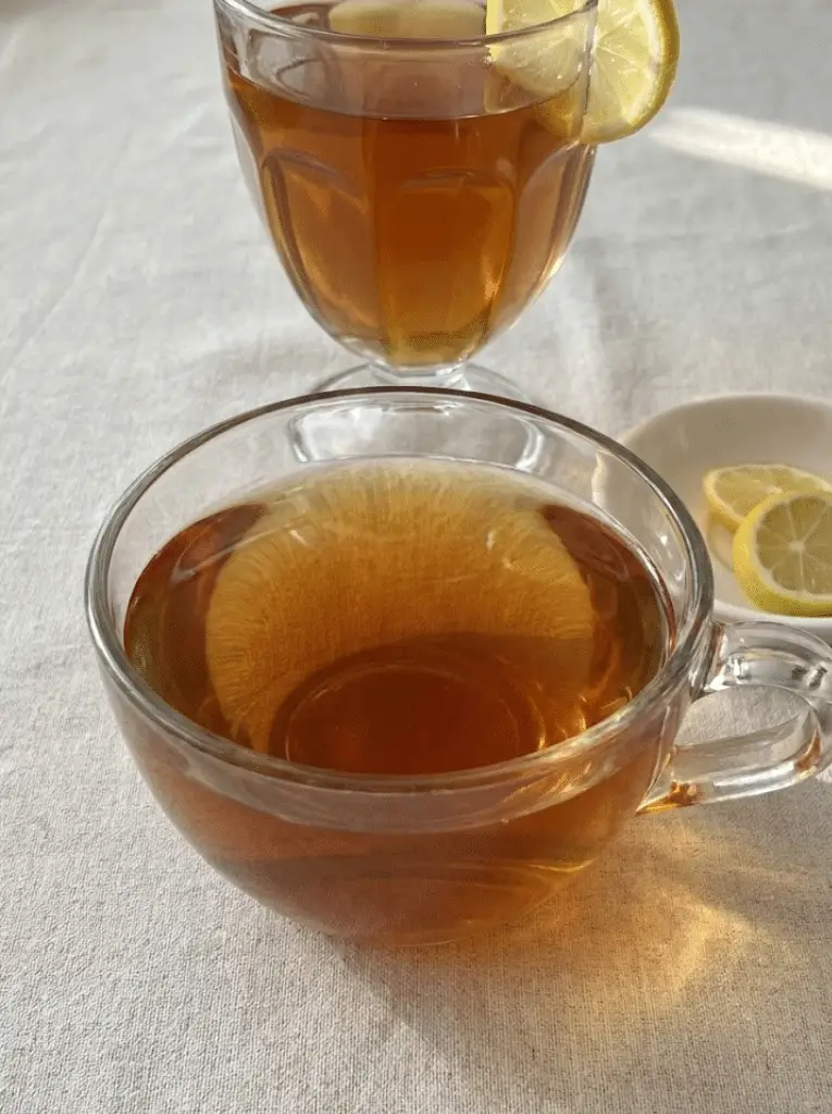 Dr Jennifer Ashton gelatin trick recipe - close-up of finished gelatin drink with lemon in clear glass cup before chilling into cubes