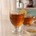 Gelatin trick recipe for weight loss - glass of homemade gelatin drink with lemon garnish on kitchen counter